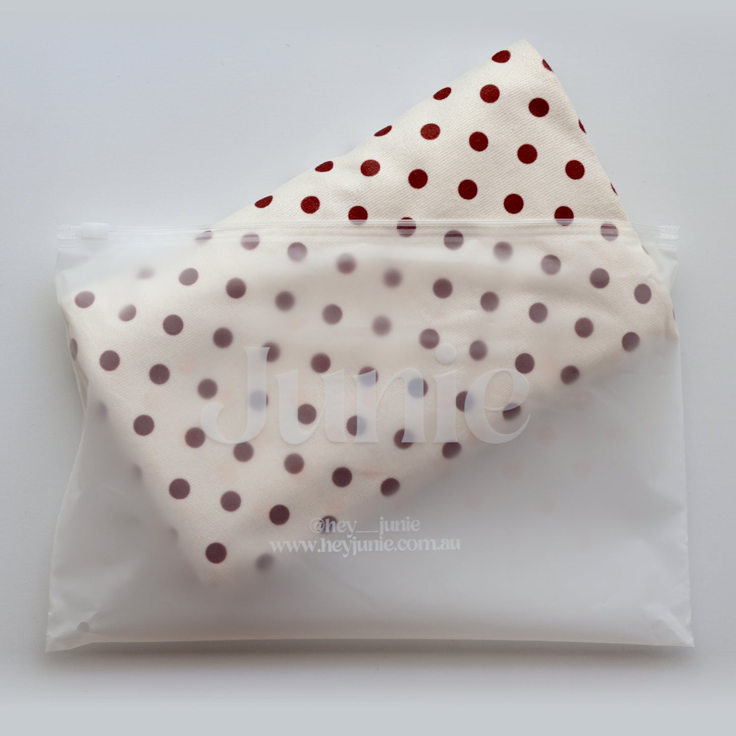 Junie fast-drying hair towel in blush polka dot pink, being removed from reusable zip-lock wet bag