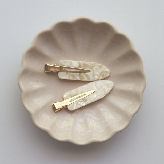 Two Junie hair clips on a scalloped ceramic dish, gentle hold during styling
