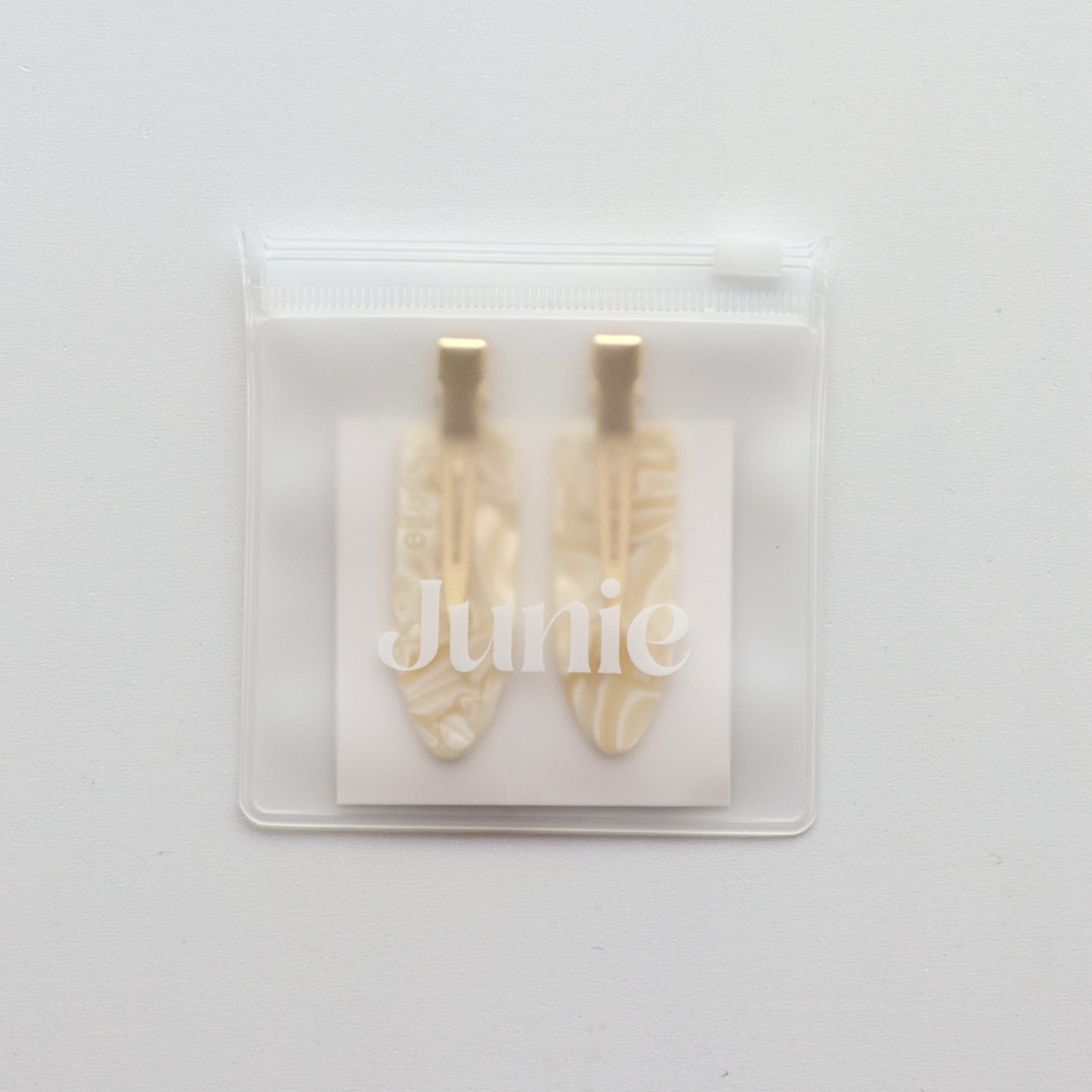 Junie crease-free hair clips in ivory with gold accents, neatly packaged in a reusable zip lock bag with Junie branding for gifting or storage
