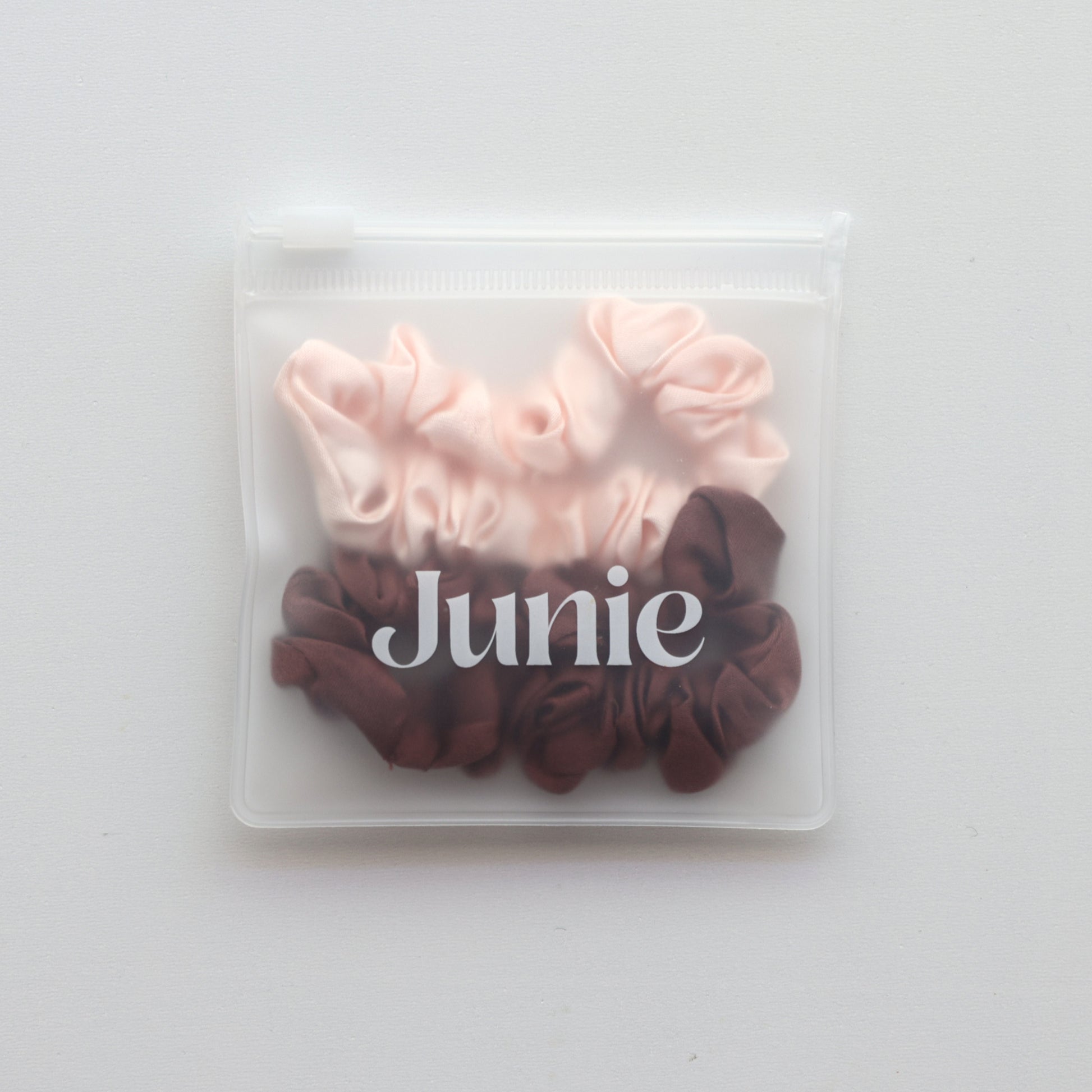 Set of pink and brown scrunchies in a clear packaging  zip lock bag with 'Junie' branding
Junie hair scrunchies in pastel colours, neatly packaged for gifting or storage