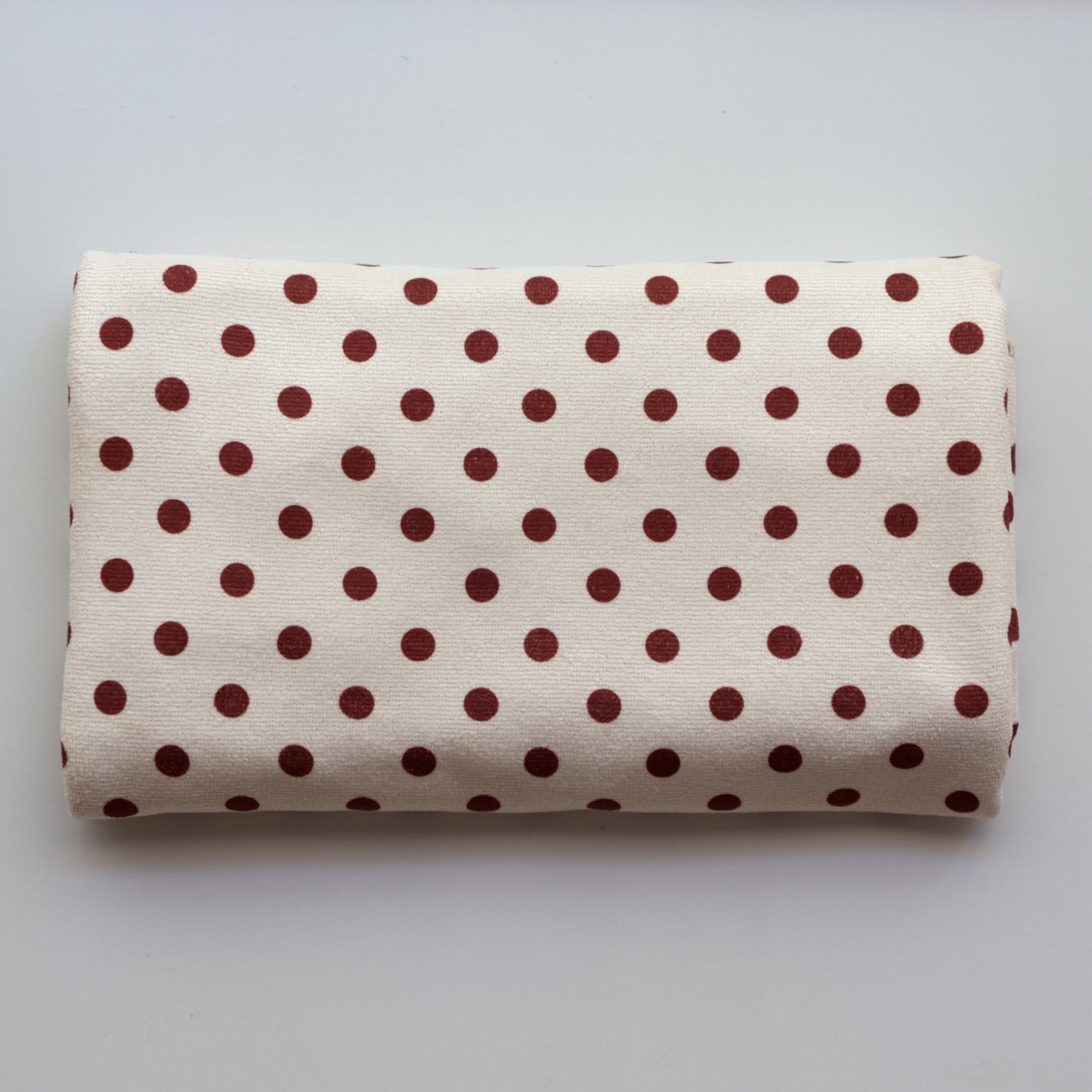 Junie fast-drying hair towel in blush pink with polka dots, neatly folded on shelf