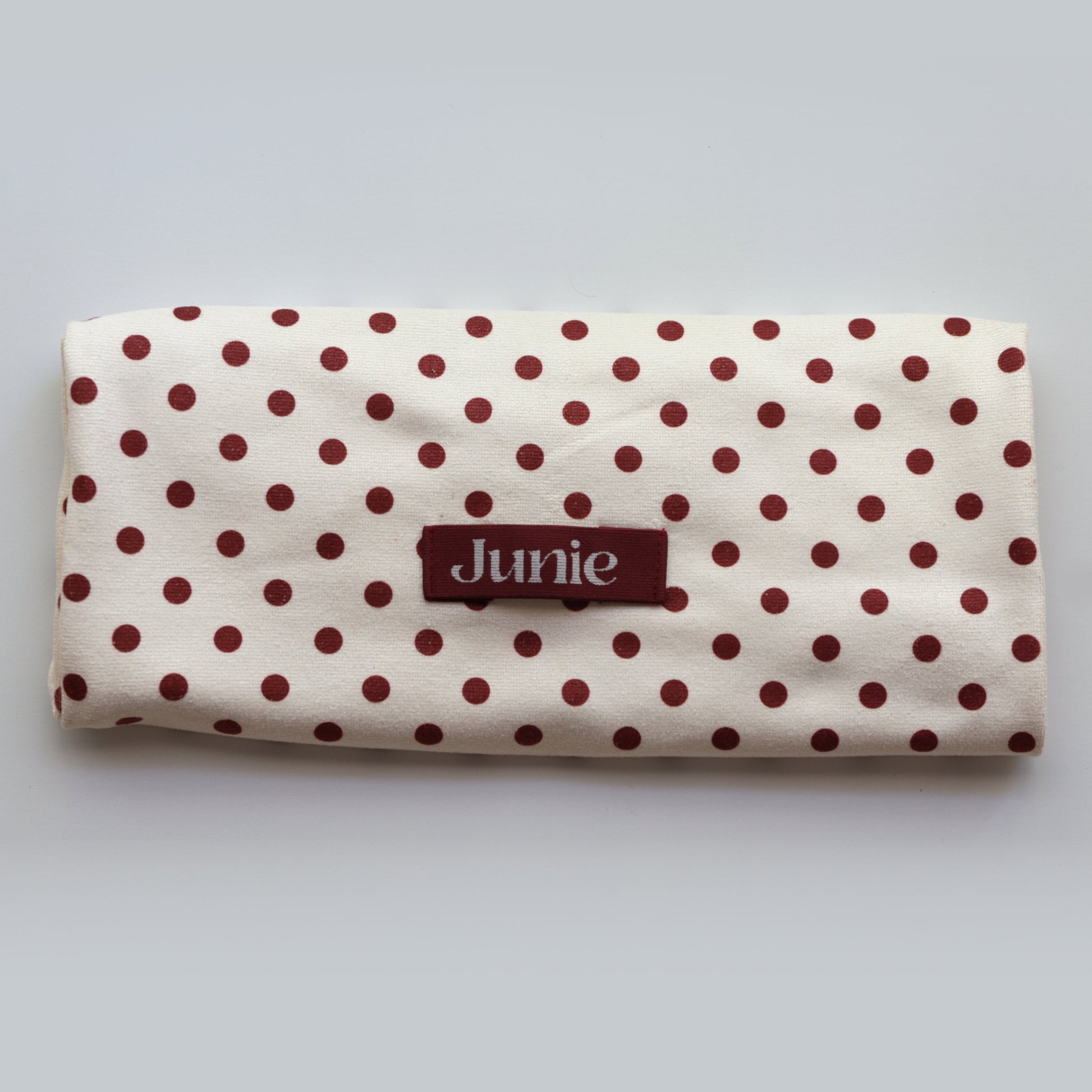 Junie fast-drying hair towel in blush pink with polka dots, neatly folded with the Junie elastic loop showing