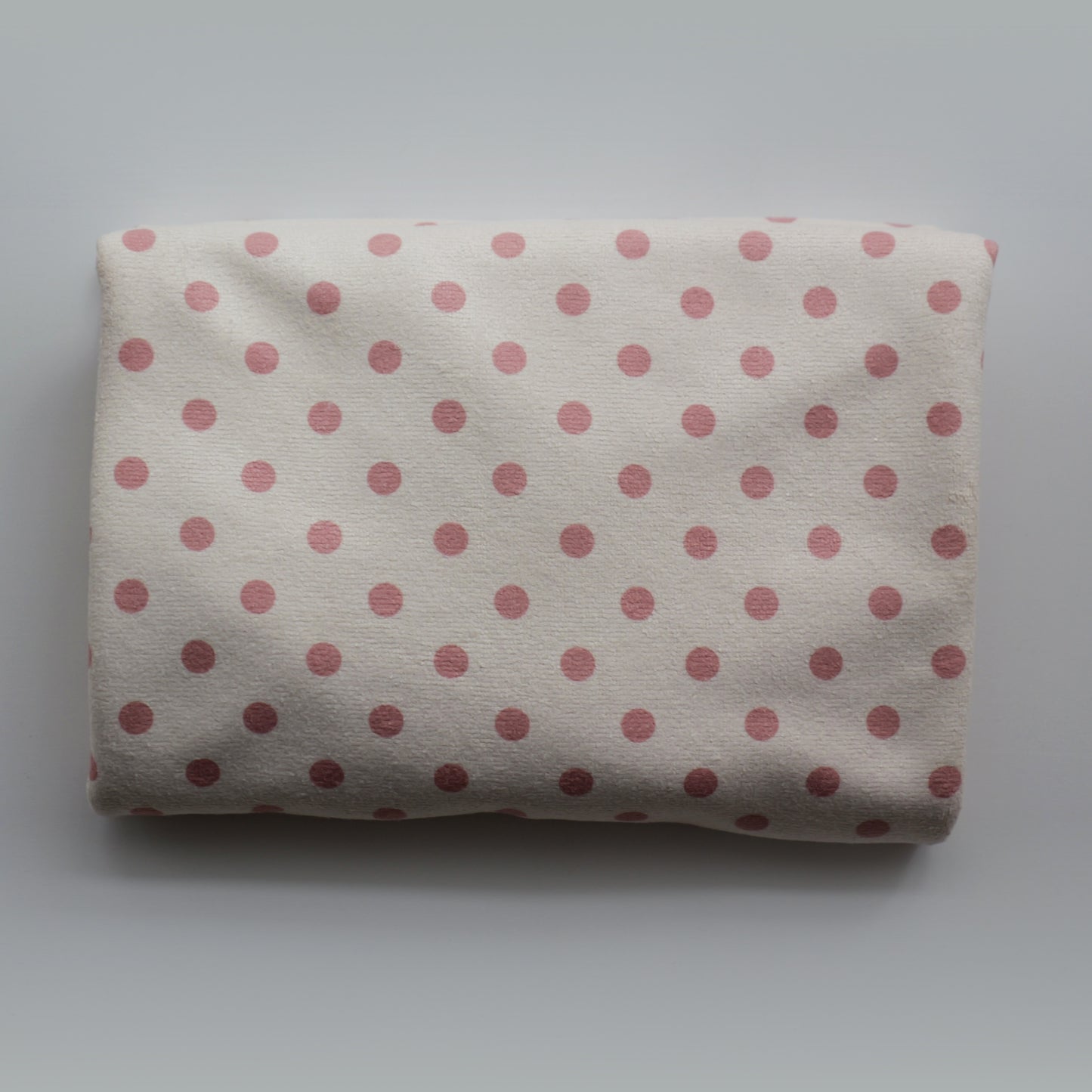Folded Junie quick dry hair towel with peaches and cream polka dots on a white background
