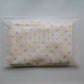 A folded white Junie quick dry kids hair towel, decorated with a pastel polka dot pattern in yellow, orange, purple, and pink. The item is sealed inside a clear plastic bag with a visible 'junie' brand watermark.